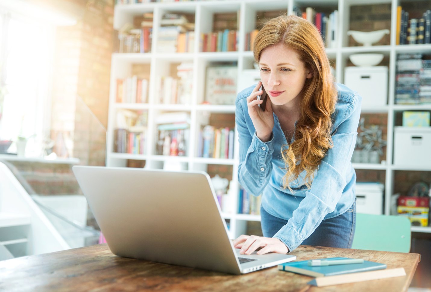 Woman using smartphone and laptop
