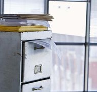 Jupiterimages/BananaStock/Getty Images Dissolving a corporation involves tying loose ends with a lot of paperwork.