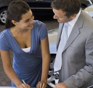 Jupiterimages/Pixland/Getty Images Your agent may sign car loan papers for you.