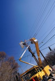 Stockbyte/Stockbyte/Getty Images Los instaladores de líneas exteriores construyen y mantienen las líneas de transmisión y distribución eléctrica.