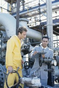 Stockbyte/Stockbyte/Getty Images Los ingenieros mecánicos pueden reunirse con los trabajadores de la producción para resolver problemas.