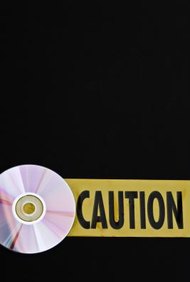 Jupiterimages/Photos.com/Getty Images Selling or giving away a burned CD is a violation of copyright law.