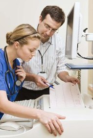 Jupiterimages/Polka Dot/Getty Images Los técnicos médicos trabajan con los doctores para asegurar que los aparatos médicos funcionen bien.