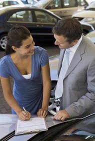Jupiterimages/Pixland/Getty Images Your agent may sign car loan papers for you.