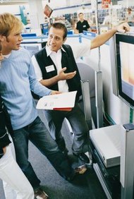 Digital Vision./Digital Vision/Getty Images El personal de ventas en planta le explica al cliente las características del producto y las garantías.