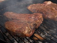 A porterhouse steak sizzling on a grill.