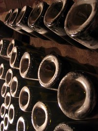Dusty bottles stored at a proper angle in a large riddling rack.