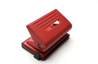 A two-hole paper punch has a lever that you push down on to make holes.