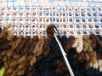 In latch hooking you use a small hooked tool to pull yarn through the holes in a canvas.