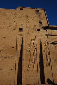In an ancient Egyptian stone carving, most figures are wearing the double crown.