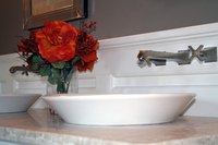 A vessel sink rests on top of or is slightly submerged in the vanity.