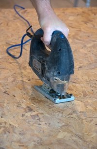 The thin cutting blade of a jigsaw allows you to cut curves in a sheet of Plexiglas.