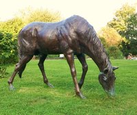 Make a stand of grass or hay out of paper mache to help support the long, fragile legs of the horse statue.