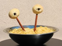 Puffy eyes poking out of a bowl of noodles