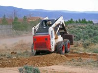 A skid loader can clear and grade land.