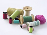 Three bobbins and thread come with the Perfect Stitch Pro machine.