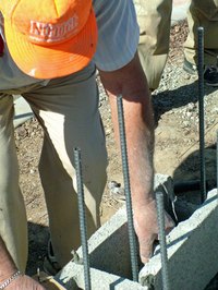 String of stretcher bar visible as mason positions block.