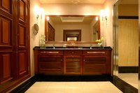 A clean, wood frame accentuates the edge of the bathroom mirror.