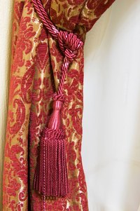 Install a curtain tieback to finish dressing a window.