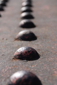 Rivets can be undone, but not without leaving a hole in the material.