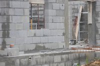 Tyvek sheeting can be installed over cinder block construction with the use of masonry screws.