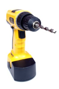 A DeWalt cordless drill with a twist drill bit installed in the keyless chuck.