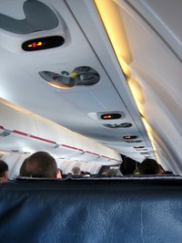 A flight attendant makes sure passenger's needs are taken care of.