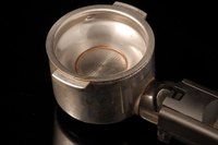 The portafilter quickly accumulates coffee residue, and should be cleaned regularly.