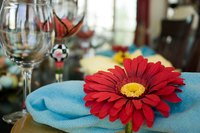 A traditional rolled napkin with a flower napkin ring spices up a table setting.