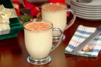 Two glasses of eggnog garnished with nutmeg.