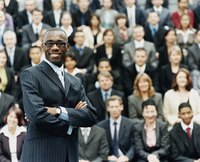 Adult male business leader stands in front of his colleagues