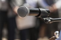 A microphone in front of a blurred crowd of people.