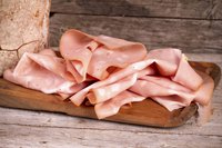 Sliced mortadella meat on cutting board
