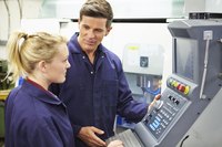 Engineer teaching an trainee how to use a machine.