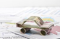 Bank notes folded and rolled to look like an automobile on top of paperwork.