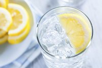 Fresh lemon water in tall glass.