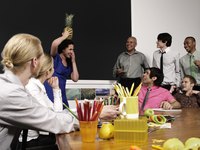Co-workers goofing around in office lunch room.