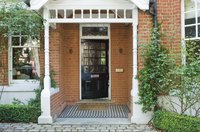A simple column portico with a gabled roof complements a Victorian home.