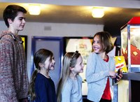 Children lining up for popcorn at movie theater.