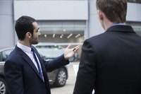Car salesman holding the keys to a new car