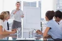 A woman giving a presentation to several business colleagues