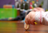 Little girl's hand spinning dreidel