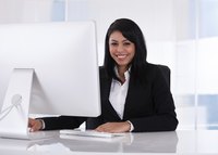A smiling businesswoman at work on her desktop computer