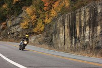 Motorcycle driving on road during autumn.
