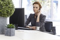A businesswoman is on the phone at work.