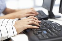 Close-up of workers typing on keyboards