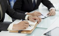 Image of two business people working on contracts.