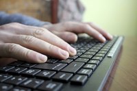 Close-up of hands typing on keyboard