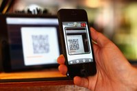 A smartphone scans a QR code posted in a shop