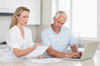 Couple creating debt goal chart in kitchen